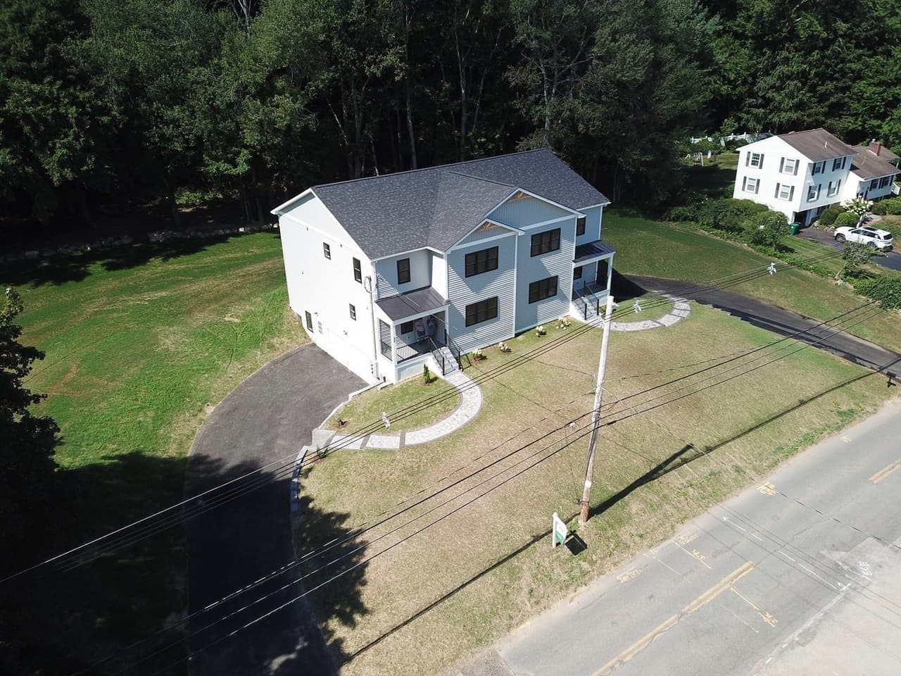 Aerial view of the property and its wooded, farm-adjacent acre