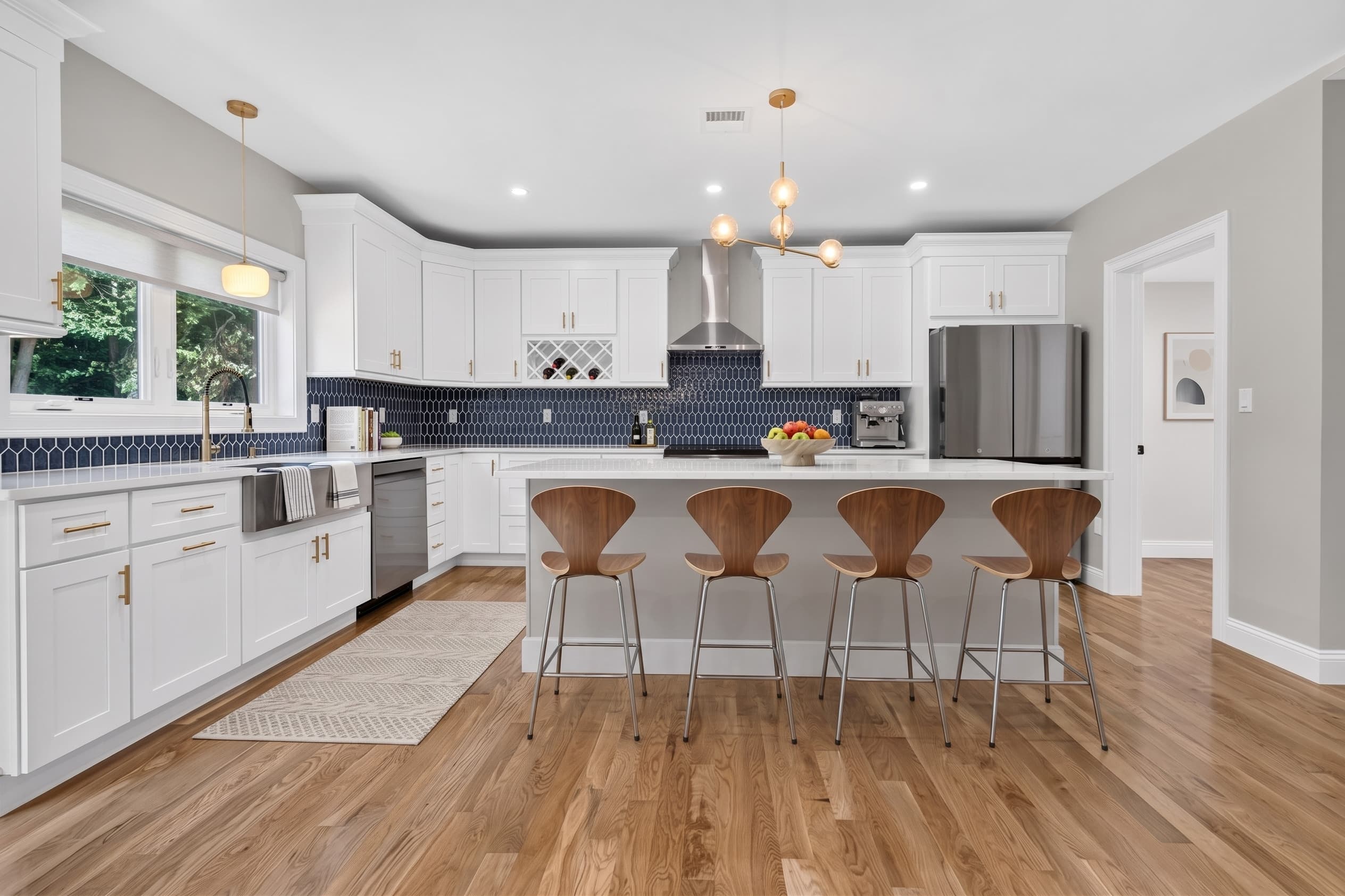 27B kitchen with navy backsplash, white waterfall island, and gold hardware