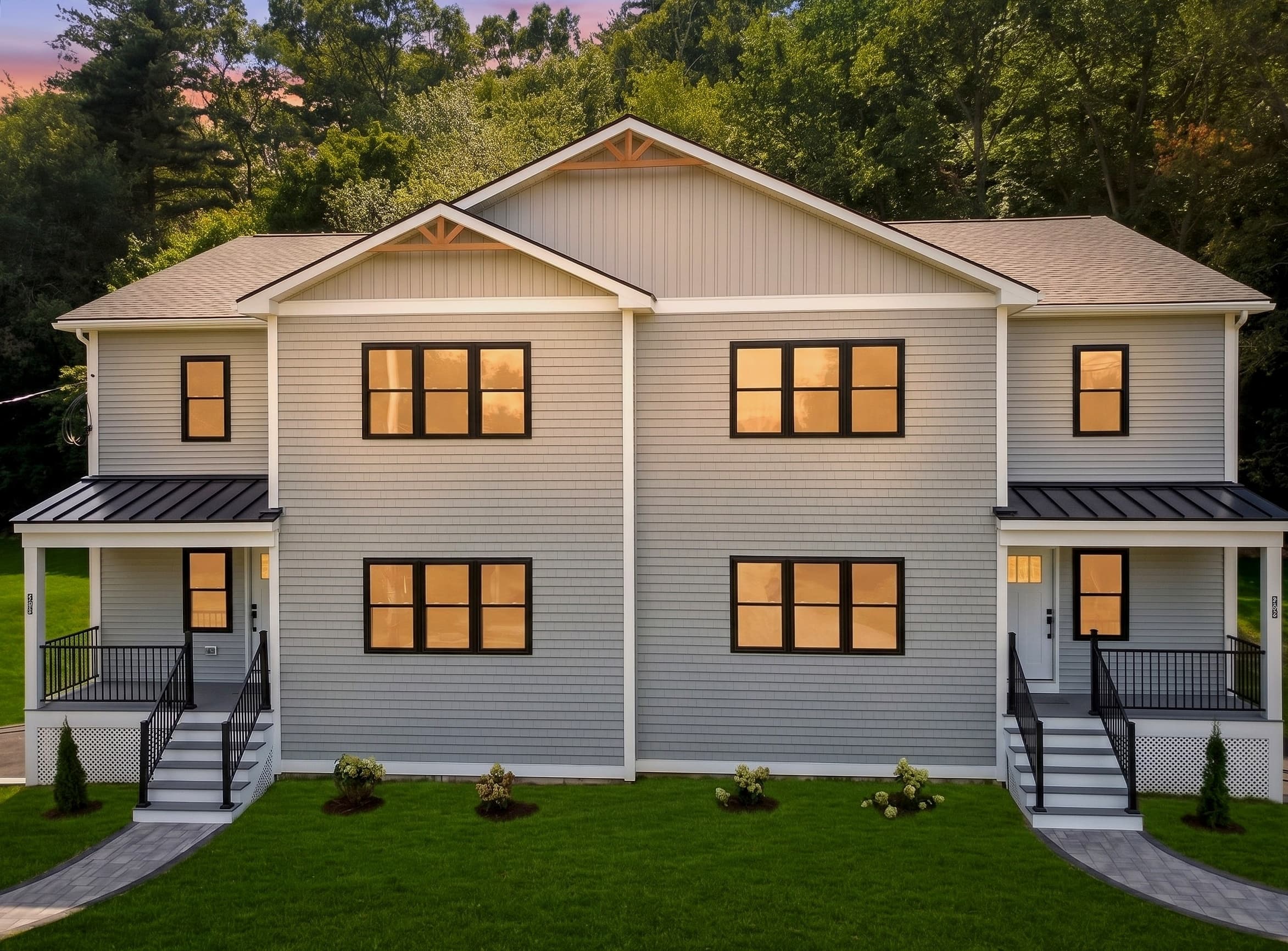 27 Rollins St at dusk — two new-construction townhomes lit against the tree line